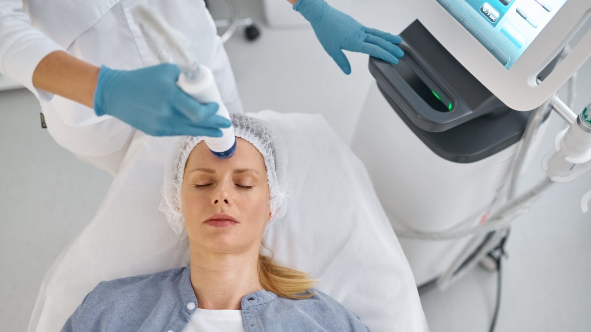 Closeup woman getting anti-aging cosmetic procedure in beauty salon. Satisfied female in disposable cap on couch at cosmetologist appointment
