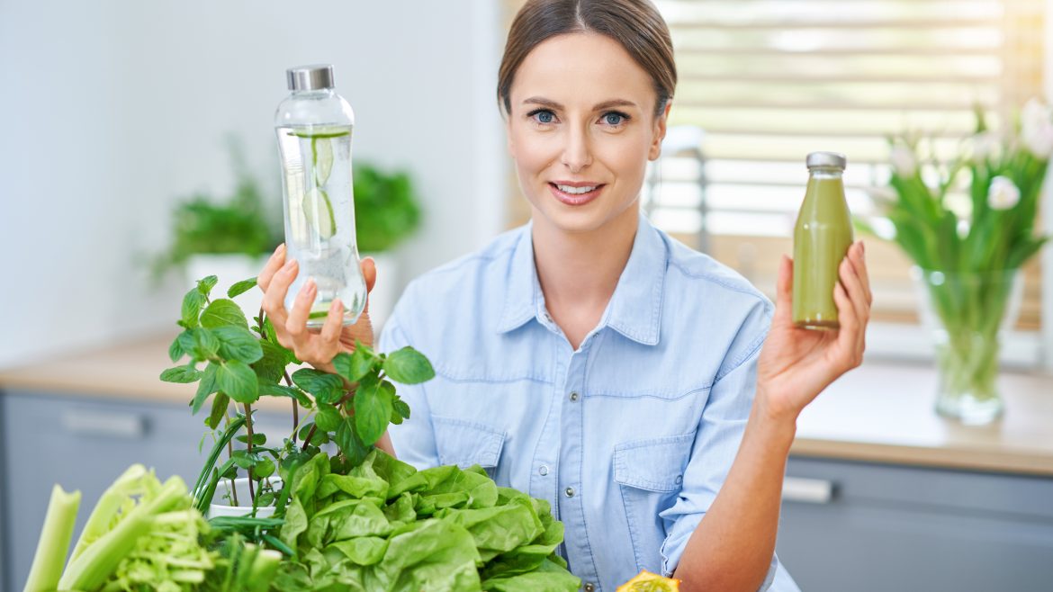 Picture of healthy adult woman with green food in the kitchen