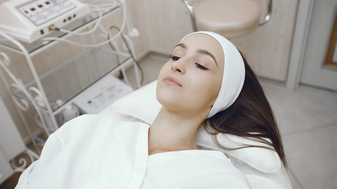 Cosmetology theme. Girl in a white bathrobe. Woman in a cosmetology studio.