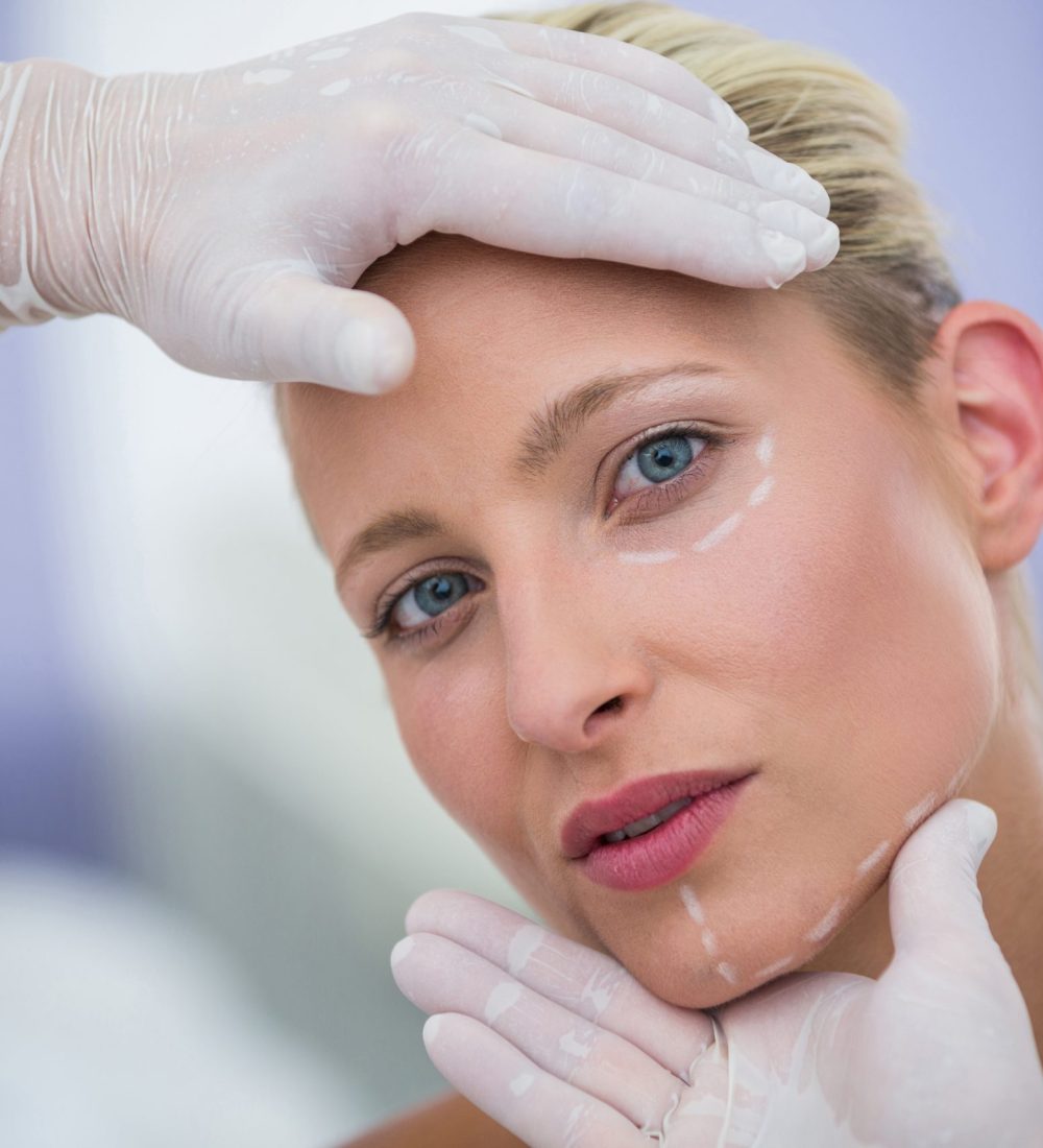 Close-up of doctor examining female patients face for cosmetic treatment