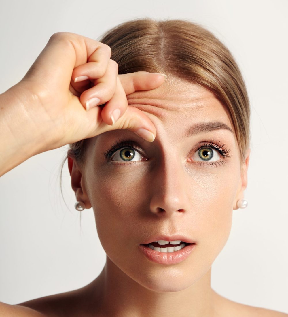young beauty woman wondering that she have wrinkles on her forehead